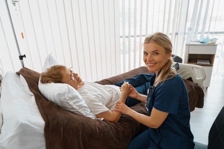 Therapist comforting patient in bed.