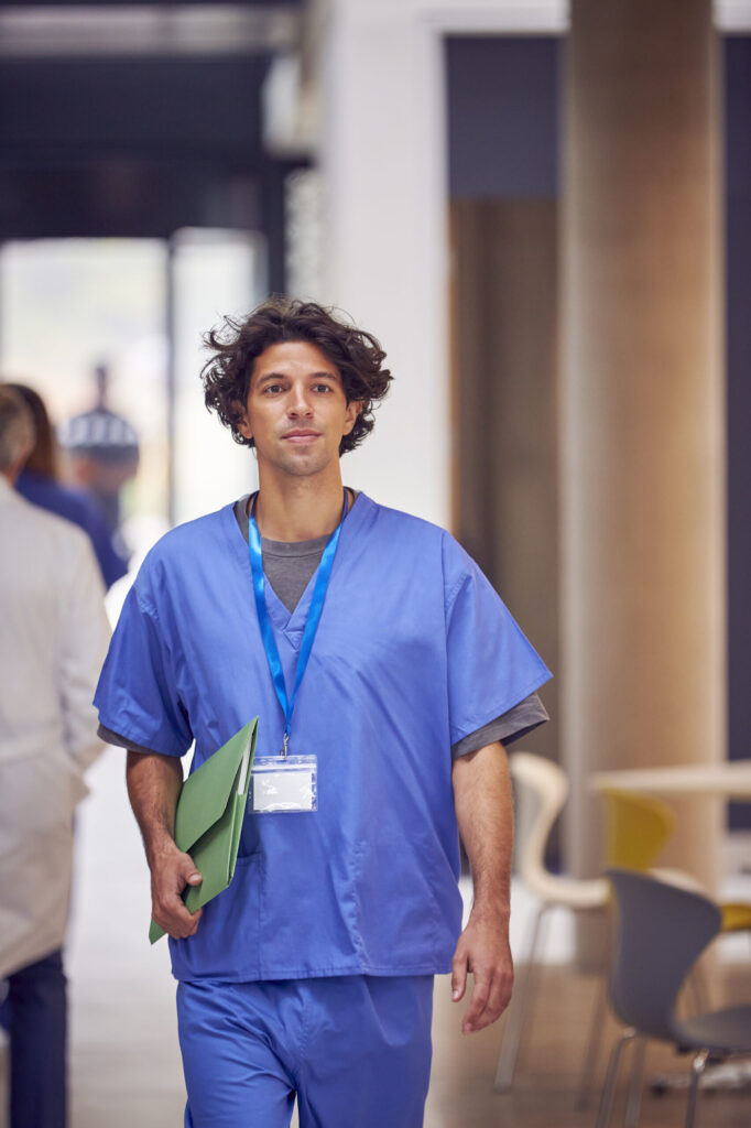 Doctor in scrubs walking confidently.