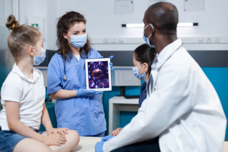 Medical professional showing tablet to children.
