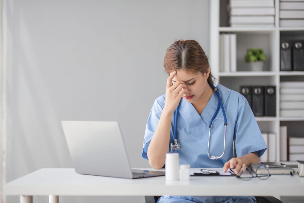 Nurse overwhelmed at her workstation.