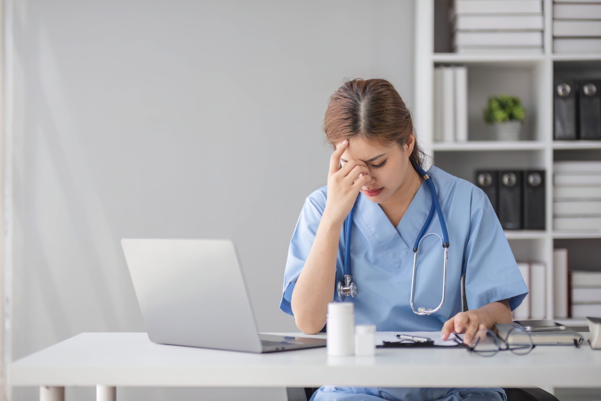 Nurse overwhelmed at her workstation.