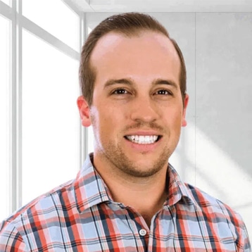 Man in checkered shirt, indoor setting.