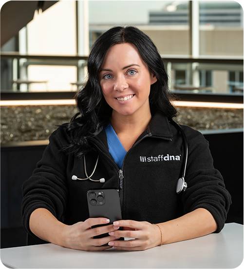 Person in medical attire holding phone.