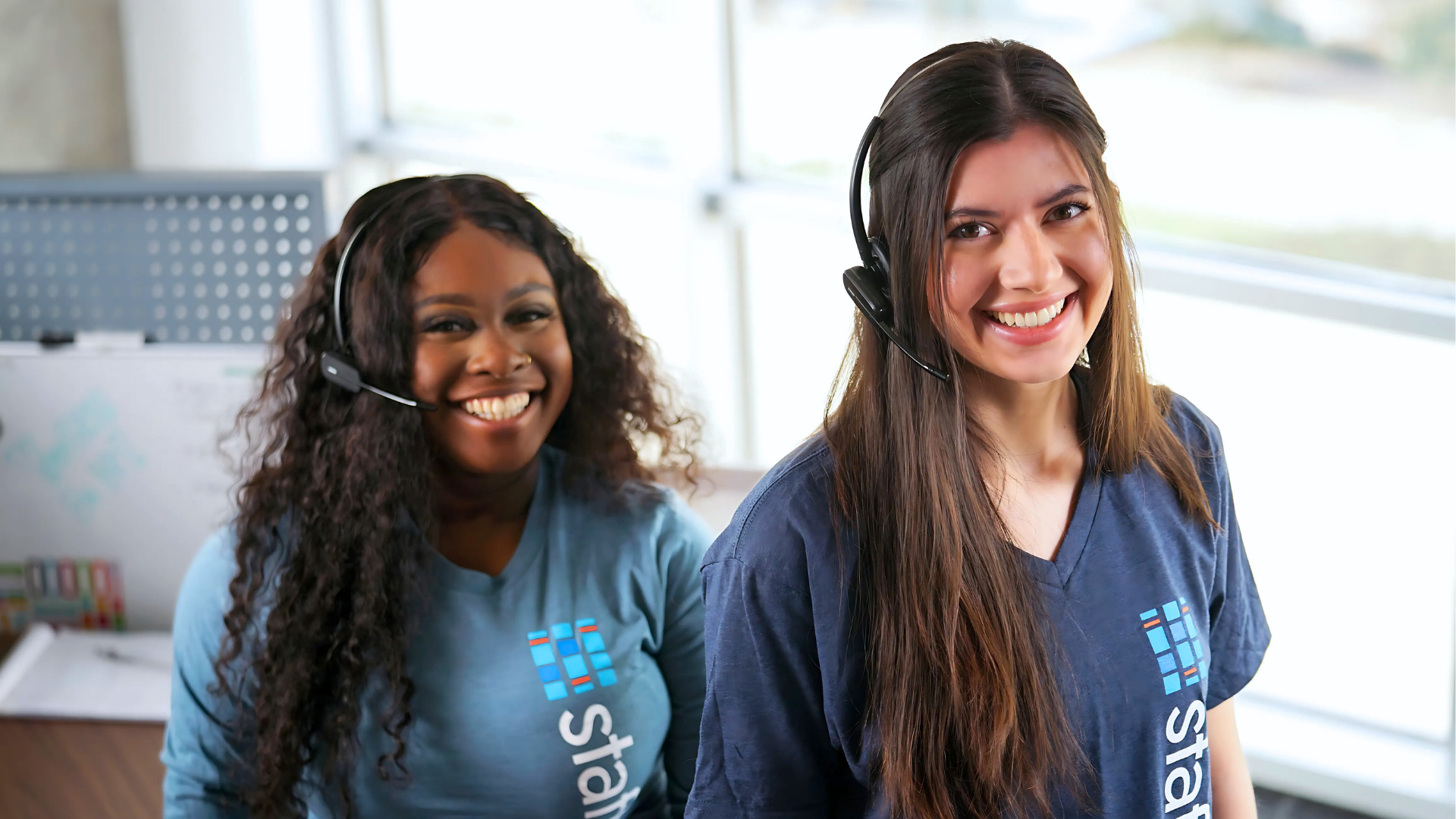Two women wearing headsets in office