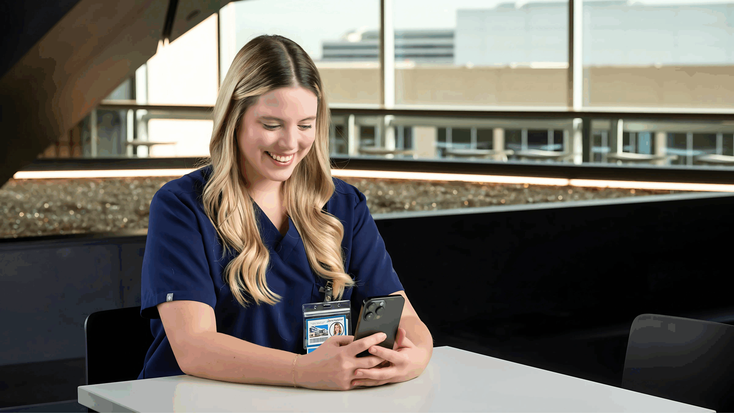 Person in scrubs using smartphone.
