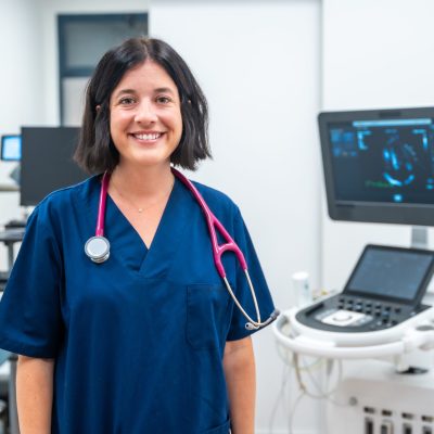 Cardiologist in medical attire, smiling.
