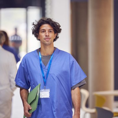 Doctor in scrubs walking confidently.