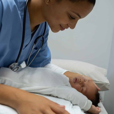 Doctor examining baby in clinic.